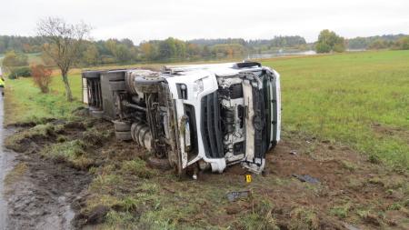 Řidič nákladního automobilu nezvládl řízení na mokré vozovce, celý náklad skončil na poli